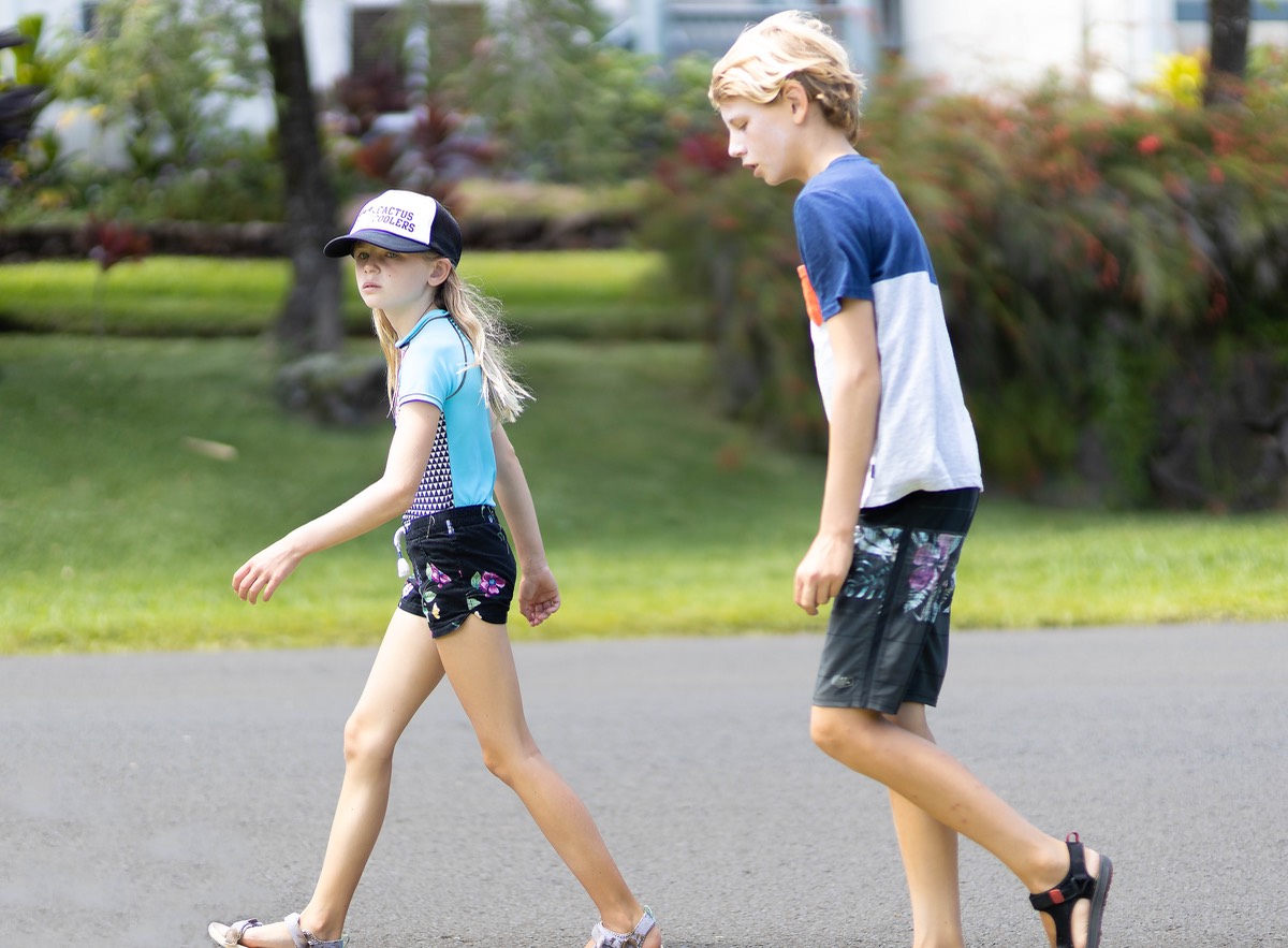 Preteen brother and sister walking in a hurry