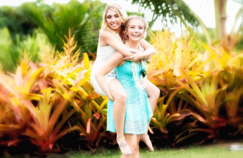 Piggyback ride bride and younger sister at Kauai wedding