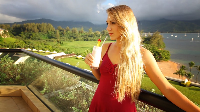 Model Tiera sucking on a straw on the terrace of the St Regis hotel, Kauai